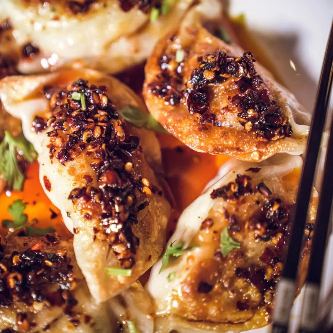 Close-up of dumplings with a spicy topping on a plate