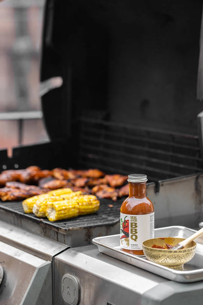 New York Shuk Harissa BBQ Sauce near a grill