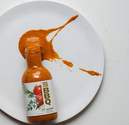 Bottle of New York Style BBQ sauce with a splash on a white plate