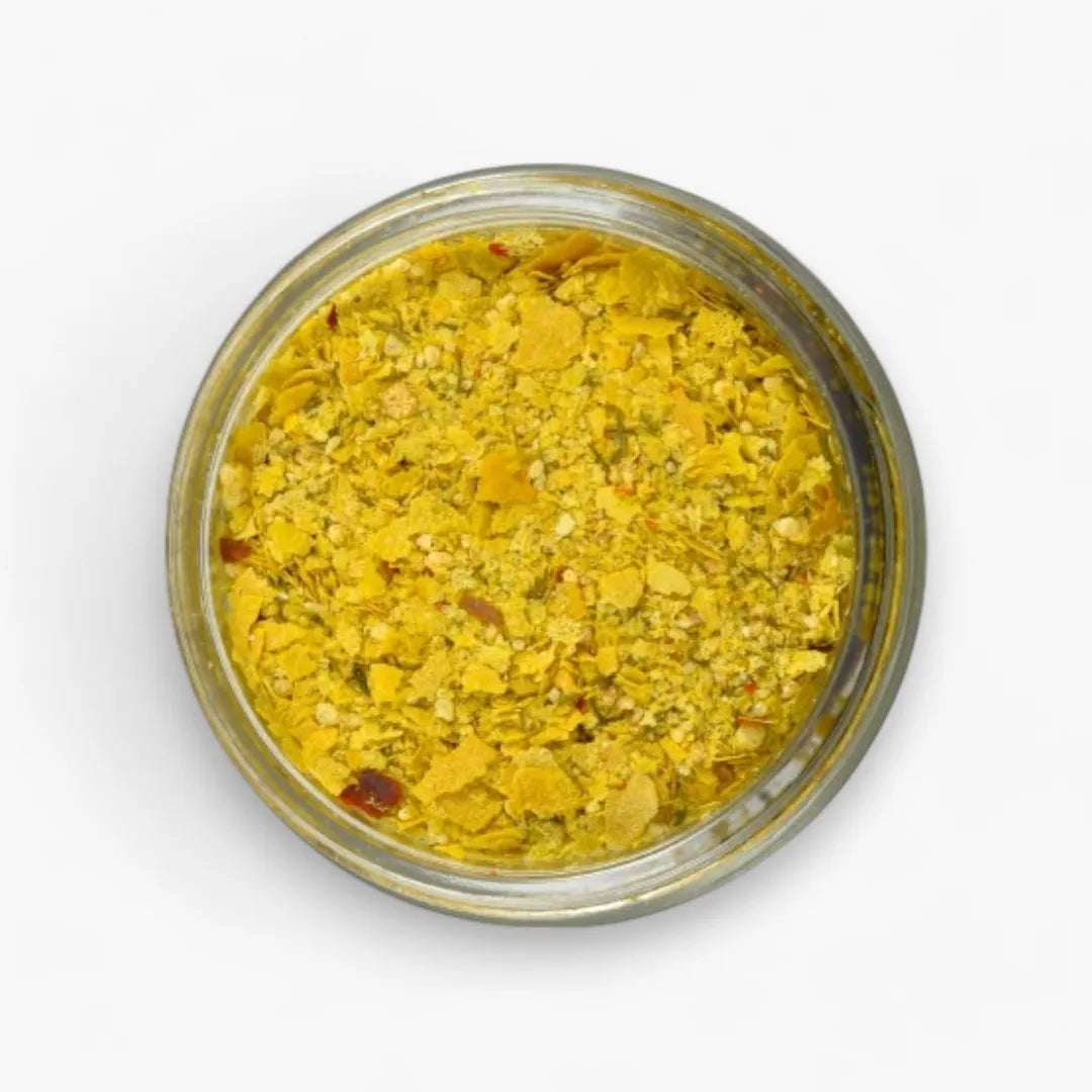 Jar of yellow spice mix on a white background